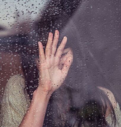 girl in front of rainy window